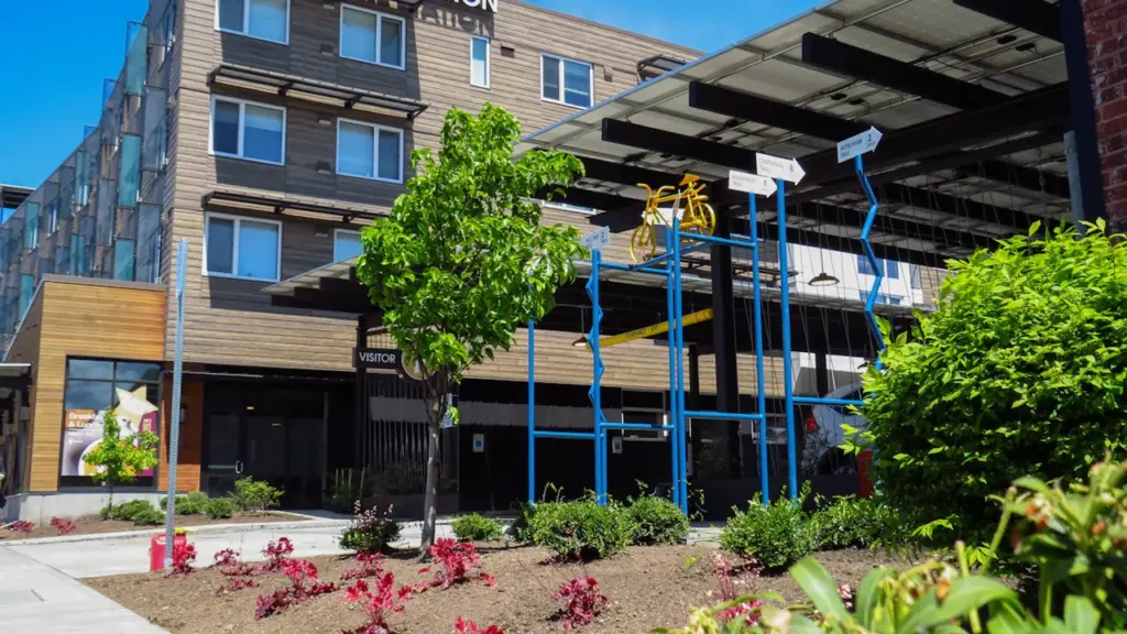 Un bâtiment communautaire moderne avec un vélo stylisé devant, symbole de réparation et partage.