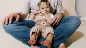 Un bébé assis sur les genoux d'un adulte dans un environnement calme et accueillant.