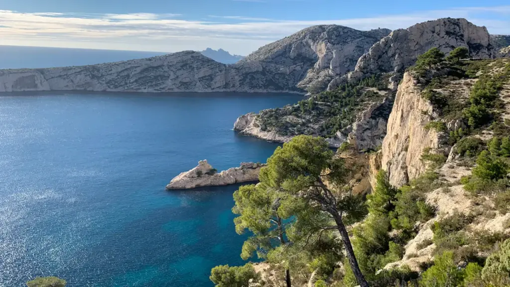 Vue aérienne des calanques de Marseille avec rochers escarpés et mer azur.