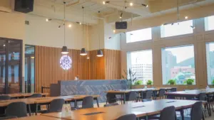 Salle de restaurant moderne avec tables en bois et chaises confortables dans un espace lumineux