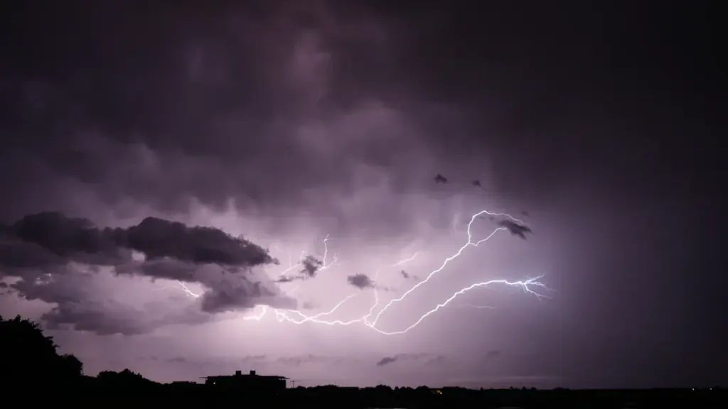 Un impressionnant orage avec des éclairs frappant au-dessus d'une zone urbaine en France.