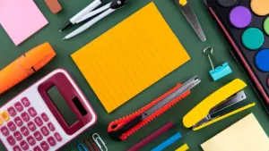 Fournitures scolaires variées disposées sur un bureau pour la préparation de la rentrée.