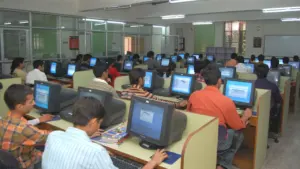 Une salle informatique remplie d'étudiants travaillant sur des ordinateurs de bureau.