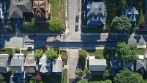 Vue aérienne d'un quartier résidentiel calme avec des arbres et des maisons individuelles.