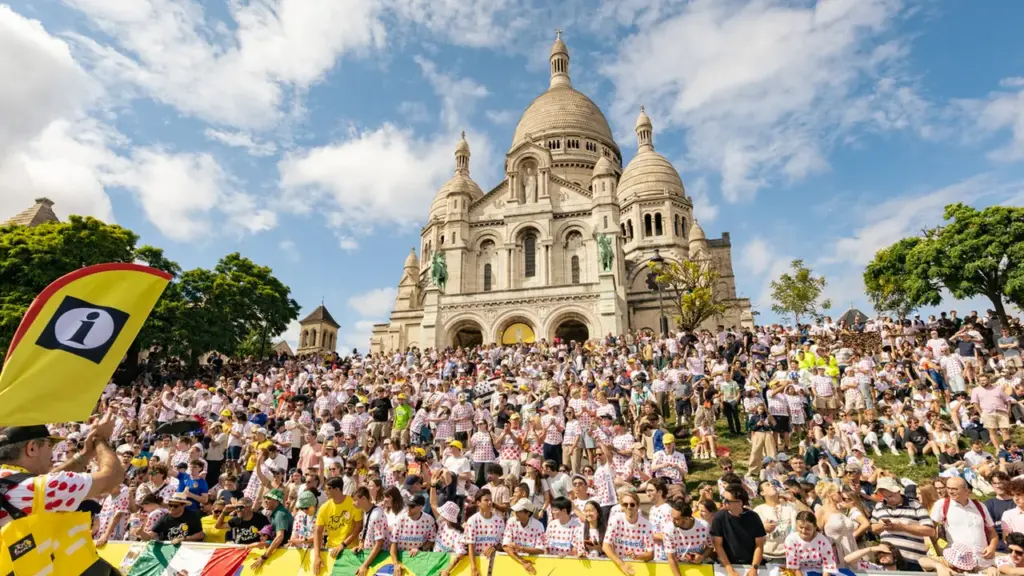 Une foule immense porte des maillots à pois devant la basilique du Sacré-Cœur à Paris.