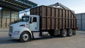 Un camion blanc avec une benne métallique pour la collecte des encombrants.