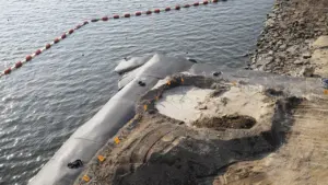 Chantier de travaux publics avec barrière de protection contre les inondations et remblais.