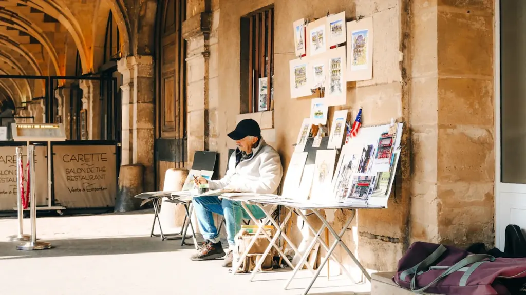 Un artiste exposant ses peintures sous les arcades historiques d'Aix-en-Provence.