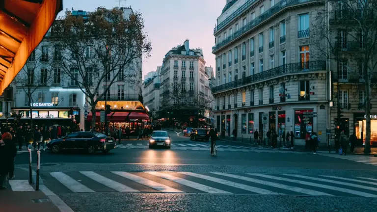 Une rue française typique avec une voiture noire circulant près d'un passage piéton.