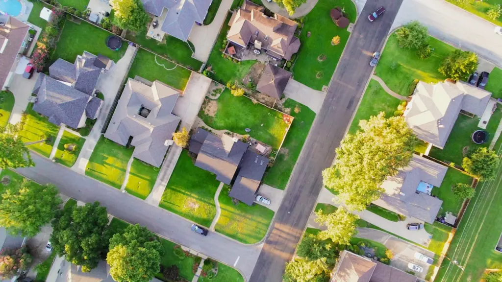 Vue aérienne d'un quartier résidentiel verdoyant avec des maisons individuelles bien entretenues.